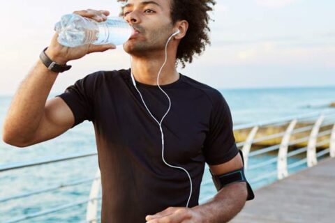 Man drinking water while jogging